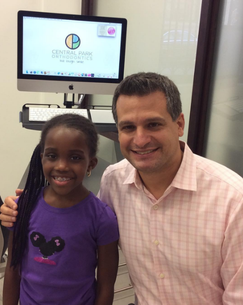Invisalign treatment being applied to a happy teenager in Harlem, NYC.